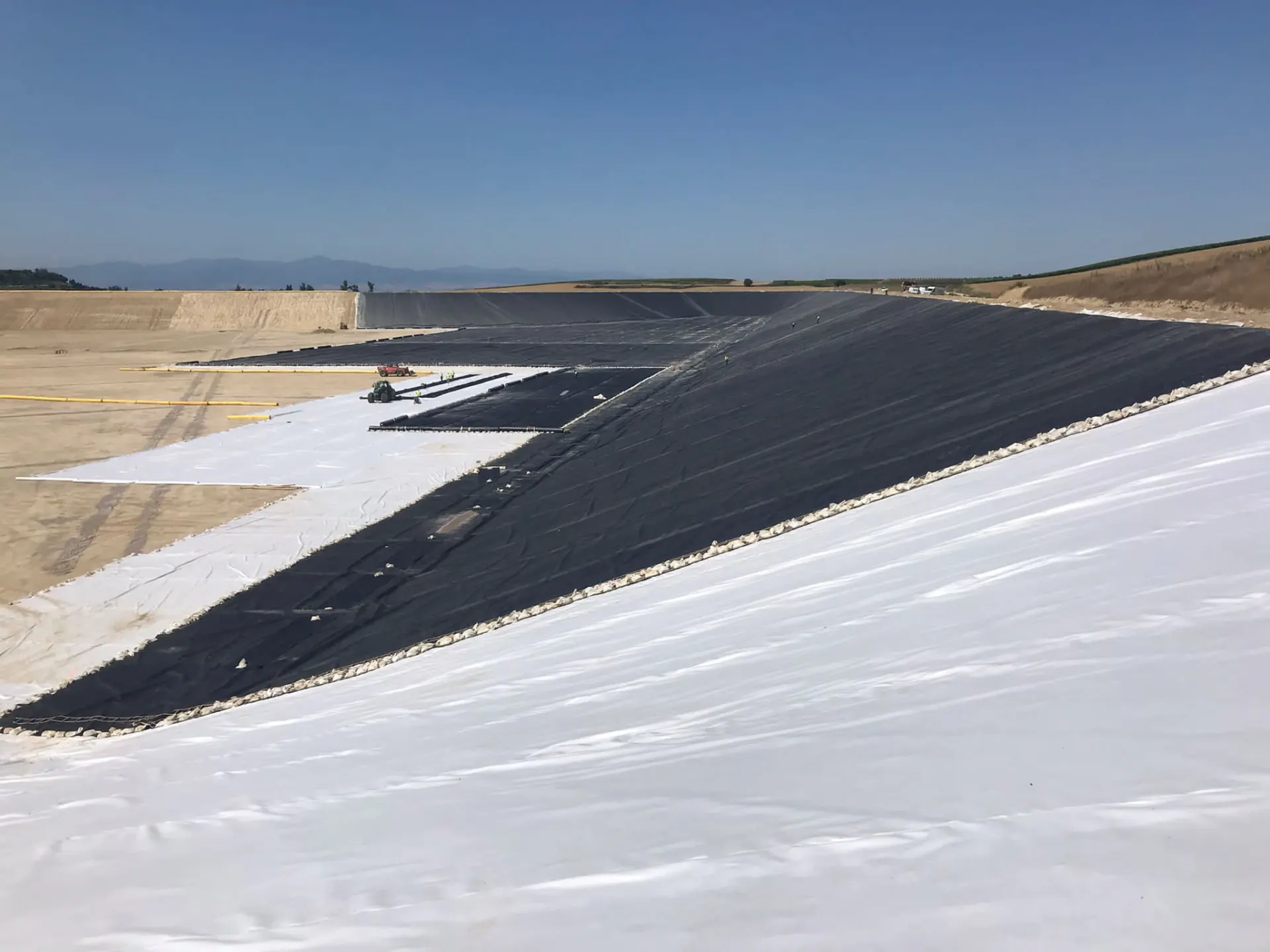 Geomembrana PEAD sobre geotextil en talud de balsa